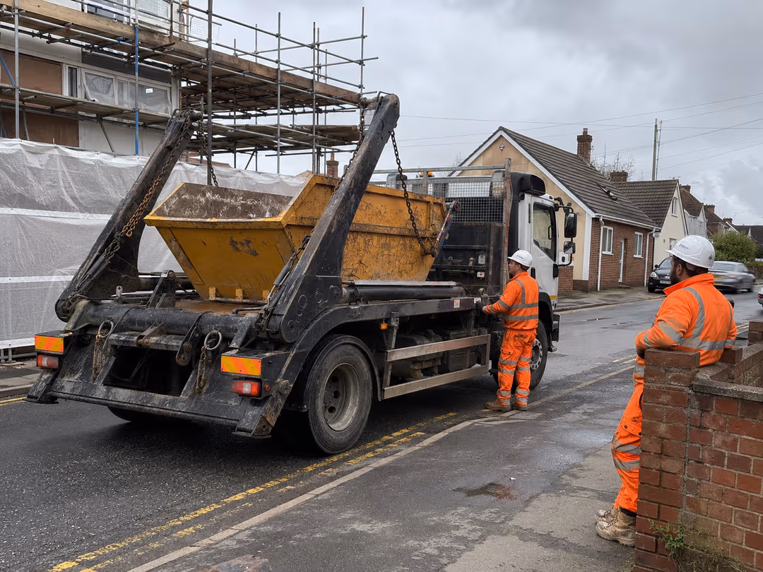 LoadSnap - operatives loading a skip onto a lorry, the kind of waste movement the platform tracks